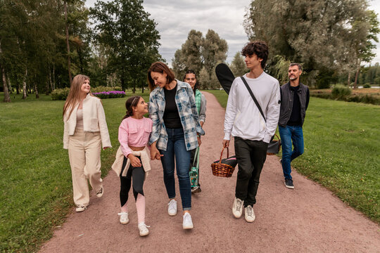 Happy family walking along park path after picnic.