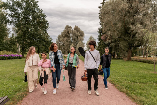 Happy family walking along park path after picnic.