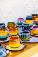 colorful ceramic cups on wooden table retale outdoors