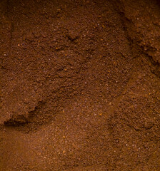 Close up of ground coffee texture in rich brown color background
