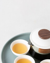 Close up of Tea being served, capturing splash and golden hues, surrounded by minimal design and organic elements