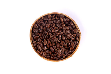 Fototapeta premium Overhead shot of roasted coffee beans filling a round woven basket on white background.
