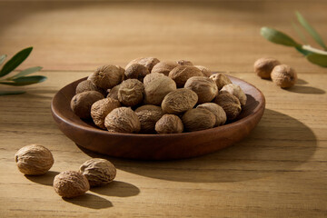 A close-up of raw shea nuts in a wooden bowl. Minimalist natural presentation for packaging...