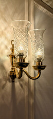 Illuminated by soft light, the textured glass shades add a touch of sophistication to the brass sconce.