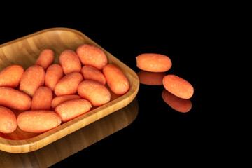 Peeled mini carrots isolated on black background, macro.