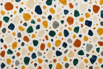 Close-up of terrazzo surface with multicolored stone chips in orange, green, blue, and beige on a white background, ideal for design and decoration.