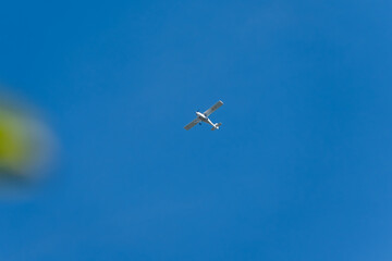 Small airplane in blue sky. A small propeller airplane flies against a clear blue sky. The minimalist scene captures freedom in flight.