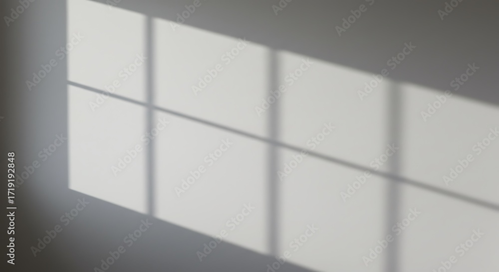 Poster sunlight streaming through a window creating geometric shadows on a plain white wall, highlighting a
