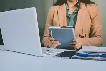 Close-up of businessman's hands making notes, mobiles, chart, desk, office
