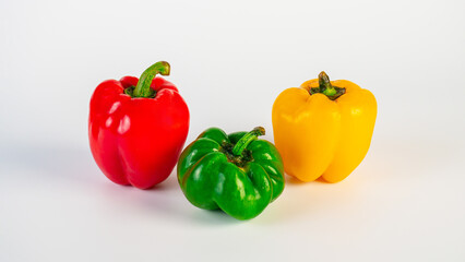Red,yellow and green sweet peppers on white background
