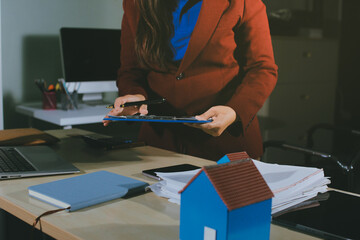 Customer signing a real estate contract in real estate agency.