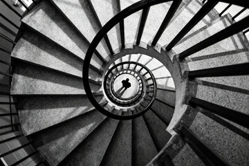 Black and white spiral staircase with a person at the center, viewed from above