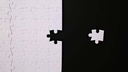 jigsaw puzzle with one piece left on black background, completing a task or solving a problem 