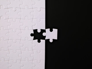 jigsaw puzzle with one piece left on black background, completing a task or solving a problem 
