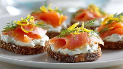 Five canap?s of smoked salmon atop creamy cheese spread on dark bread rounds, garnished with lemon zest and dill sprigs, arranged on a white plate