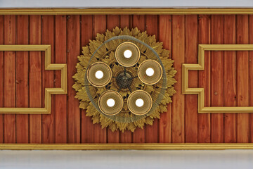A luxurious chandelier with an intricate design, featuring a beautifully carved wooden ring surrounding the lamp.