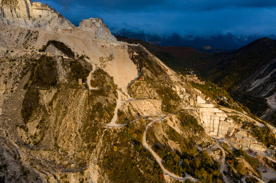 Aerial view of stark white gashes cutting through the verdant hillsides of the marble quarries, a testament to human intervention against nature's canvas, Carrara, Tuscany, Italy.