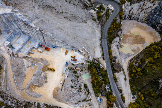Aerial view of the contrasting textures and tones of the marble quarry, where sharp, geometric cuts meet the rugged, natural landscape, Carrara, Tuscany, Italy.
