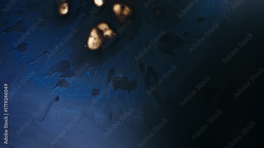 Poster liquid with dissolving particles in a dark, moody macro shot