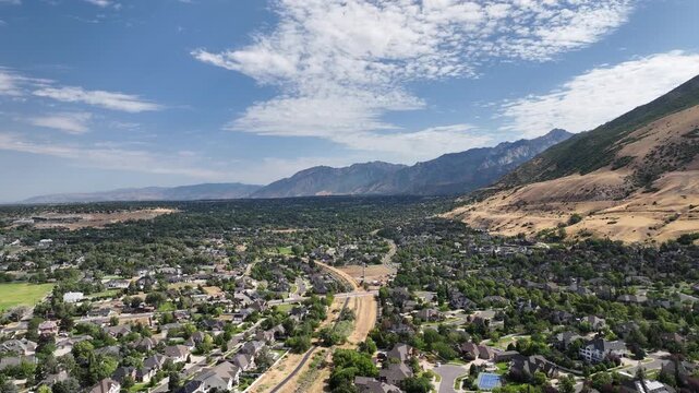 From Draper, Utah looking towards the South Salt Lake Valley along the Wasatch Front mountain range - pullback aerial flyover