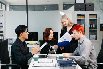 Office colleagues have a casual discussion. During a meeting in a conference room, a group of business teem sit in the conference room new startup project.