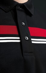 Close-up of a black collared shirt with horizontal red and white stripes across the chest, showcasing the buttons and collar detail