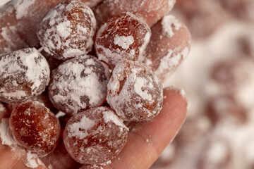 dried kumquat and powdered white sugar, sweet dried orange kumquat fruits in white sugar