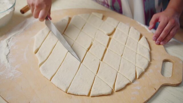 Cutting dough into small pieces for traditional baursak preparation