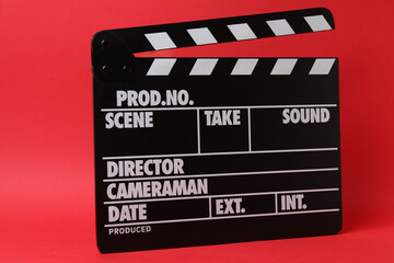 Cinema clapper and reel on a red background
