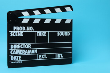 Obraz premium Cinema clapper and reel on a blue background 