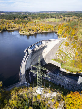 Aerial view of the dam wall, a concrete structure, casts a long shadow over the landscape, with autumn-colored trees lining the lake, Ottensteiner Stausee, Nieder&Atilde;&para;sterreich, Austria.