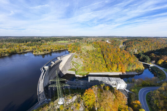 Aerial view of the Ottenstein Dam amidst a vibrant tapestry of autumnal forests, where the reservoir's dark waters meet the colorful foliage, Ottensteiner Stausee, Nieder&Atilde;&para;sterreich, Austria.