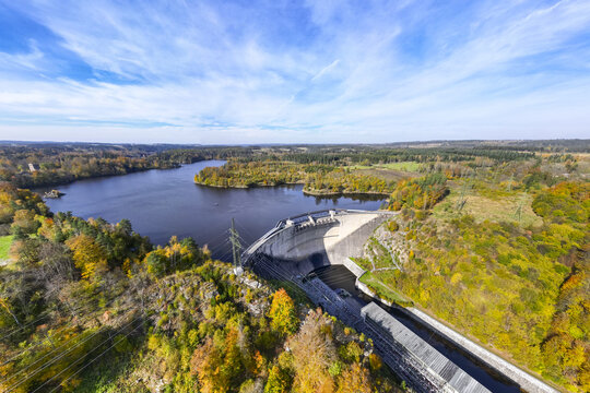 Aerial view of the dam holding back the serene waters of the Ottensteiner Stausee surrounded by autumnal forests under a vast blue sky, Ottenstein, Nieder&Atilde;&para;sterreich, Austria.
