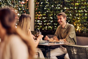 Smiling Friends Enjoying Dinner Together at a Casual Outdoor Restaurant
