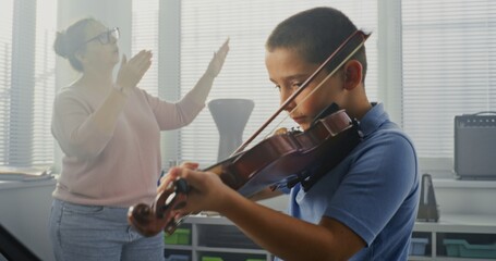 Primary School Boy Practicing Violin in Music Class, Dreaming to Become Musician. Teacher Guiding Artistic Child in Playing Musical Instrument. Musical Education, Violin Training Lesson, Rehearsal.