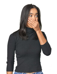 Simple portrait of a young Latina thoughtful looking to a copy space covering mouth with hand.