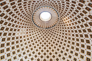 Ornate ceiling of the Rotunda of Mosta with detailed coffers, golden floral motifs, and a central oculus letting in natural light