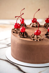 Chocolate cake decorated with maraschino cherries.