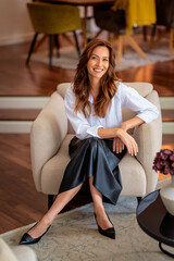 Confident middle-aged woman relaxing in her modern home