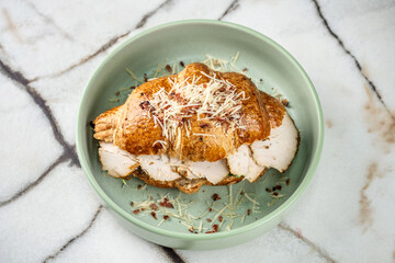 Delicious croissant sandwich filled with sliced turkey and cheese.