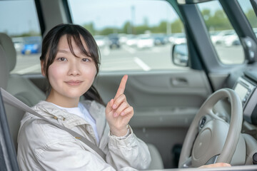 駐車場で指さす女性