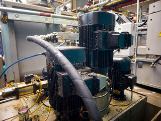 Equipment for industrial processing in a factory setting with detailed machinery and motor connections during daytime operations