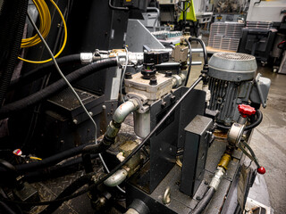 Industrial machinery showing hydraulic components in a manufacturing facility during daylight hours