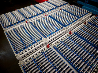 Rows of battery cells arranged in the manufacturing facility for electric vehicles near the production line