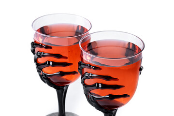 Halloween spooky red cocktail in skeleton hand glass isolated on white background