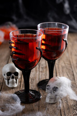 Halloween spooky red cocktail in skeleton hand glass
