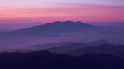 Fototapeta premium Majestic mountains stand tall under the twilight sky, where soft pink and purple hues blend gently with misty peaks, crafting an ethereal landscape that radiates calm and otherworldly beauty.