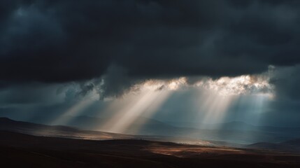 Fototapeta premium Rays of Hope: The dramatic landscape is dominated by a dark, ominous sky pierced by radiant sunbeams, casting a divine light across the rugged terrain, and evoking a sense of both awe and resilience.