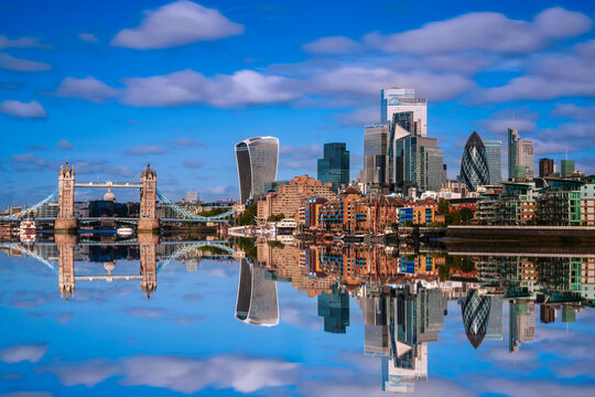 London City skyline reflected on the River Thames, a tranquil metropolitan beauty with modern high-rising architecture and Tower Bridge in the heart of the United Kingdom. - Powered by Adobe
