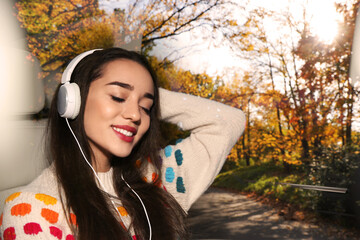 Happy woman listening to sounds of nature which making her feel calm. Double exposure with autumn landscape